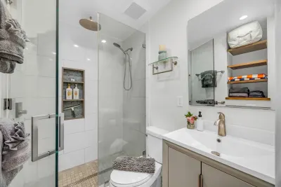Bathroom vanity and mirror beside the glass shower