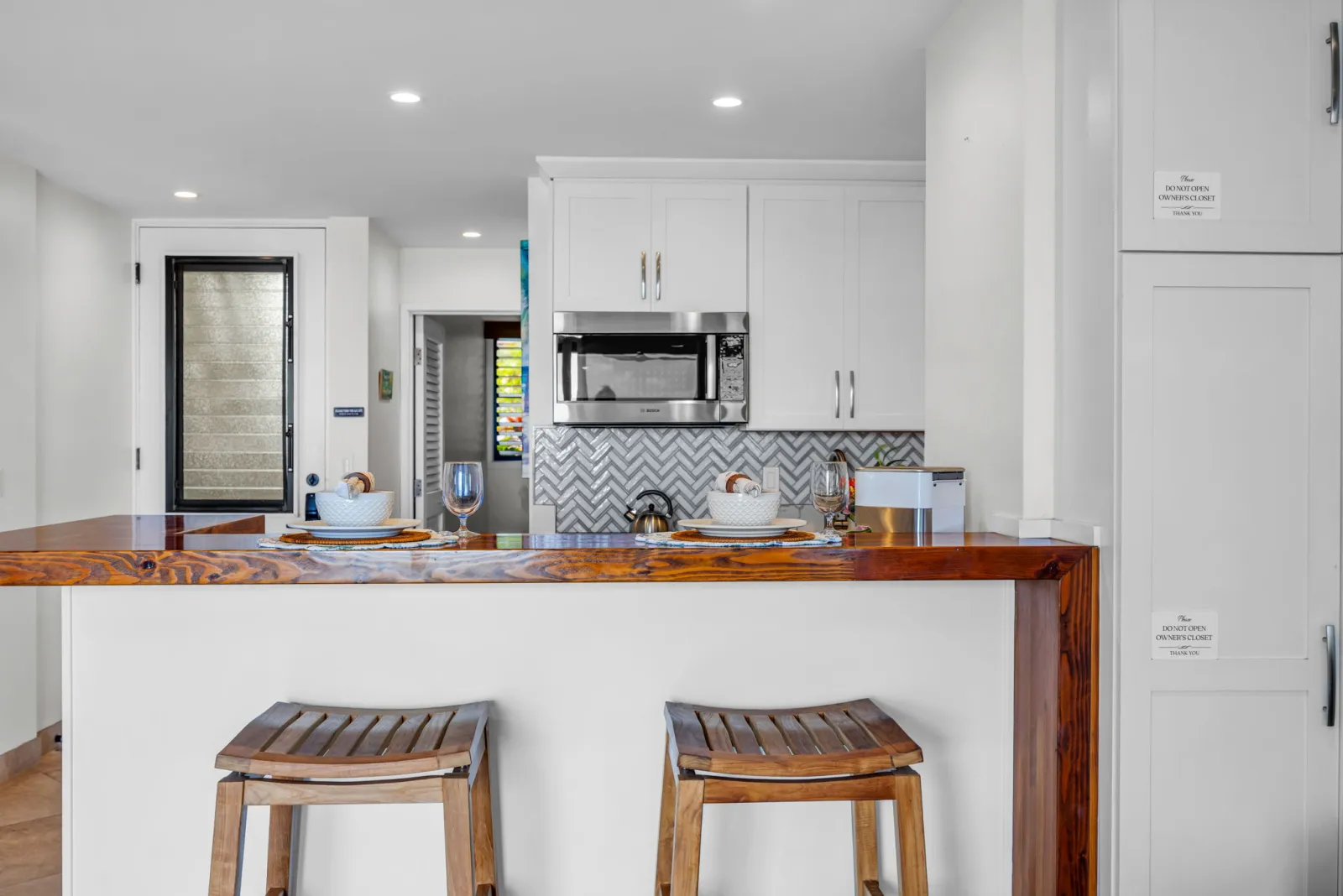 Renovated kitchen with quartz counters and a wood breakfast bar