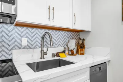 Kitchen sink and chevron tile backsplash