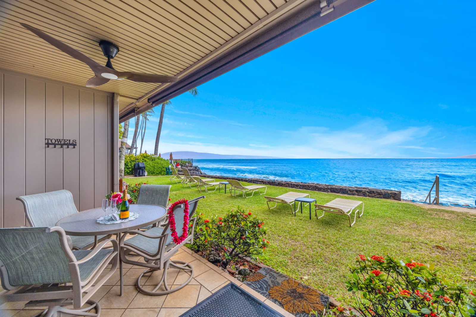 Private lanai with table and chairs opening onto the oceanfront lawn