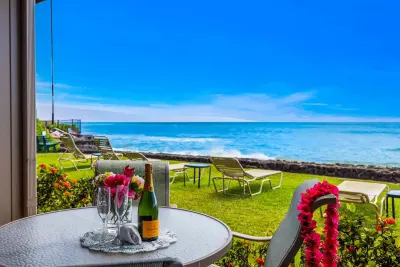 Lanai table set with glasses and flowers, ocean behind
